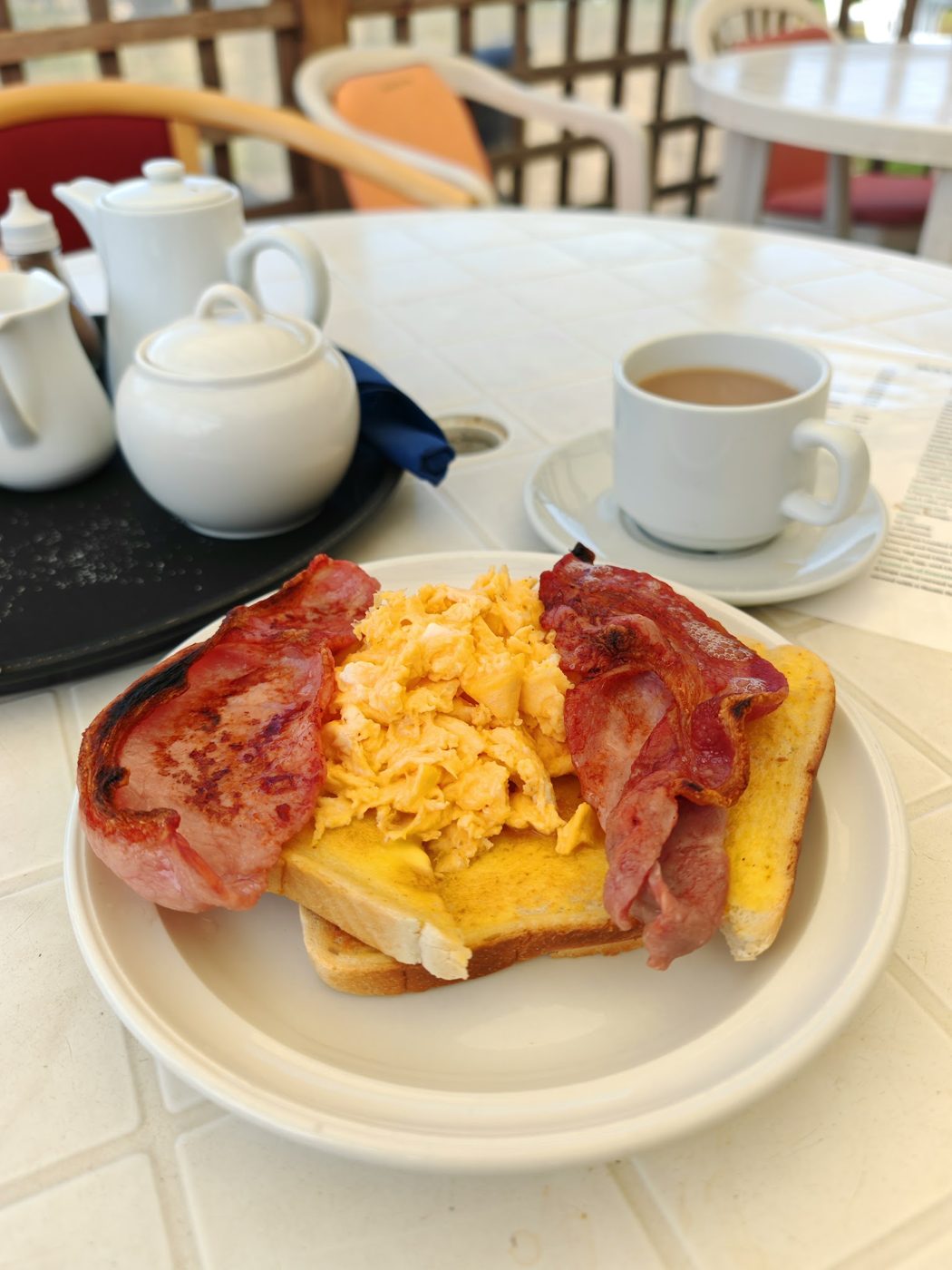 Bacon, scrambled egg and toast, with a pot of tea