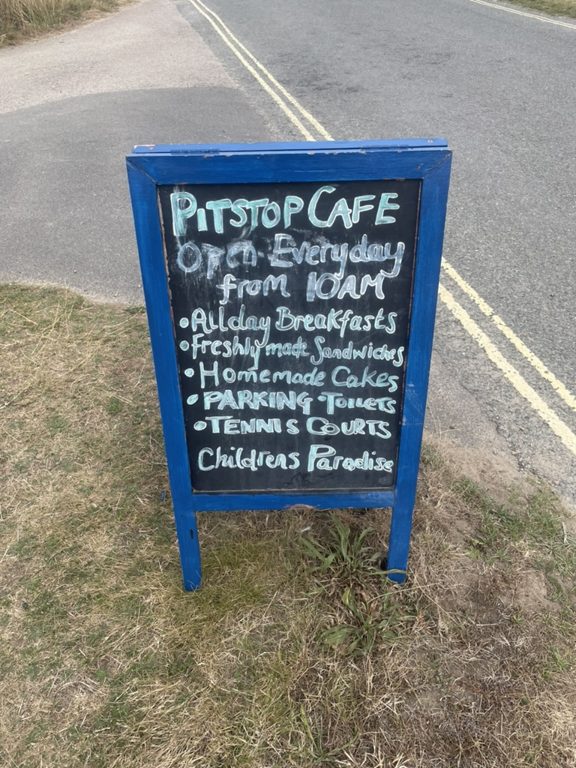 The blue Pit Stop Cafe board by the road