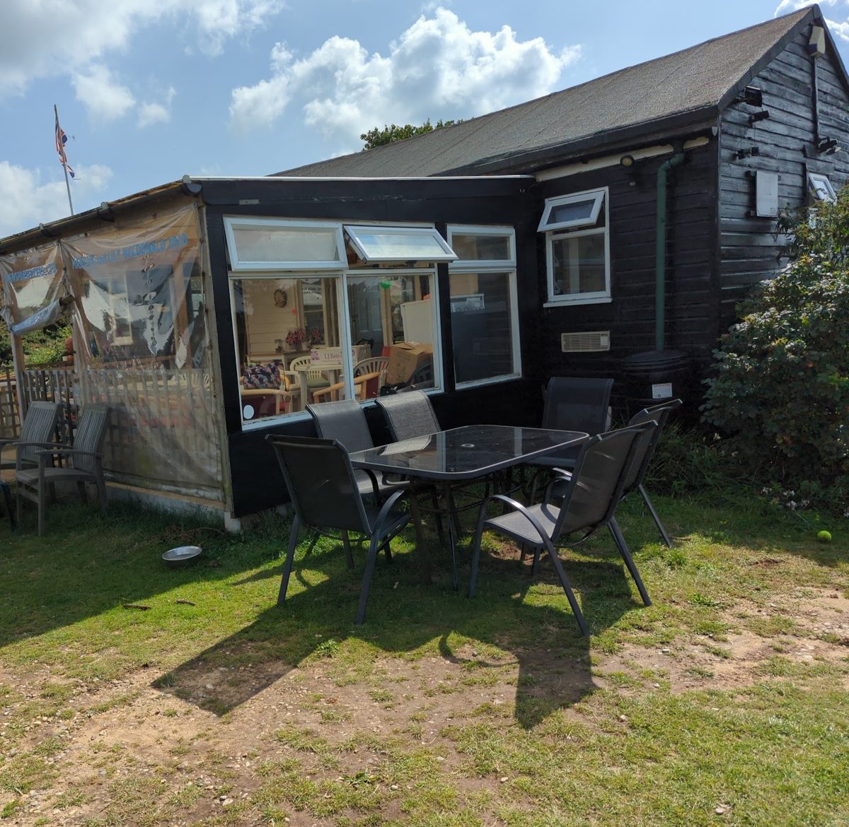 The black timber café with a conservatory and tables on the grass